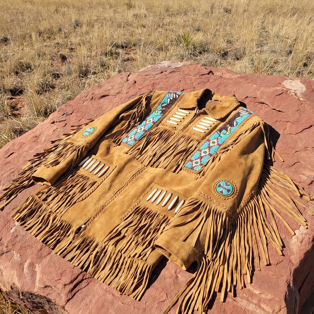 Fringe jacket laid flat on red rock showing the full beadwork and fringe